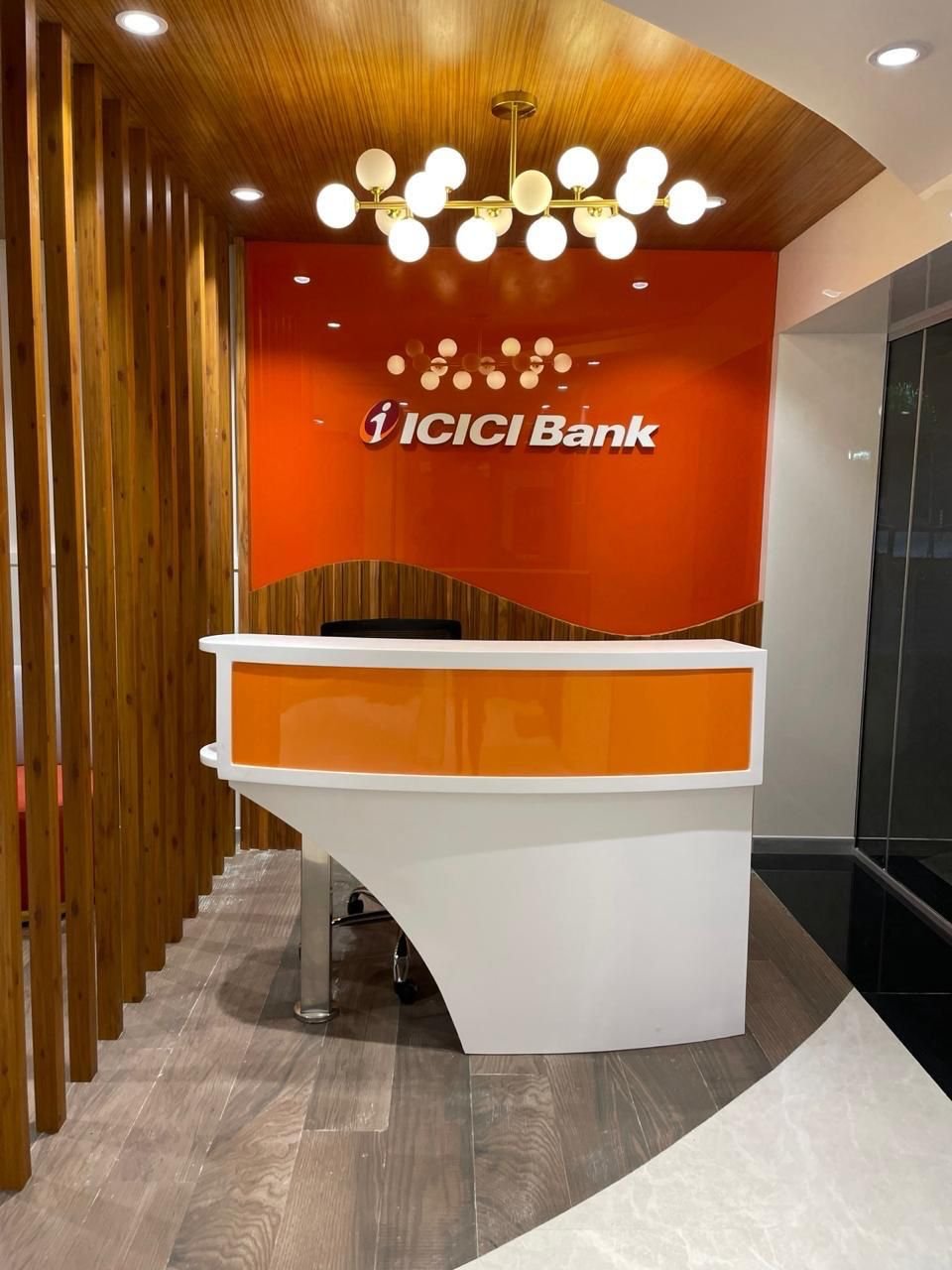 Curved orange reception counter at ICICI Bank Bagmane Neon